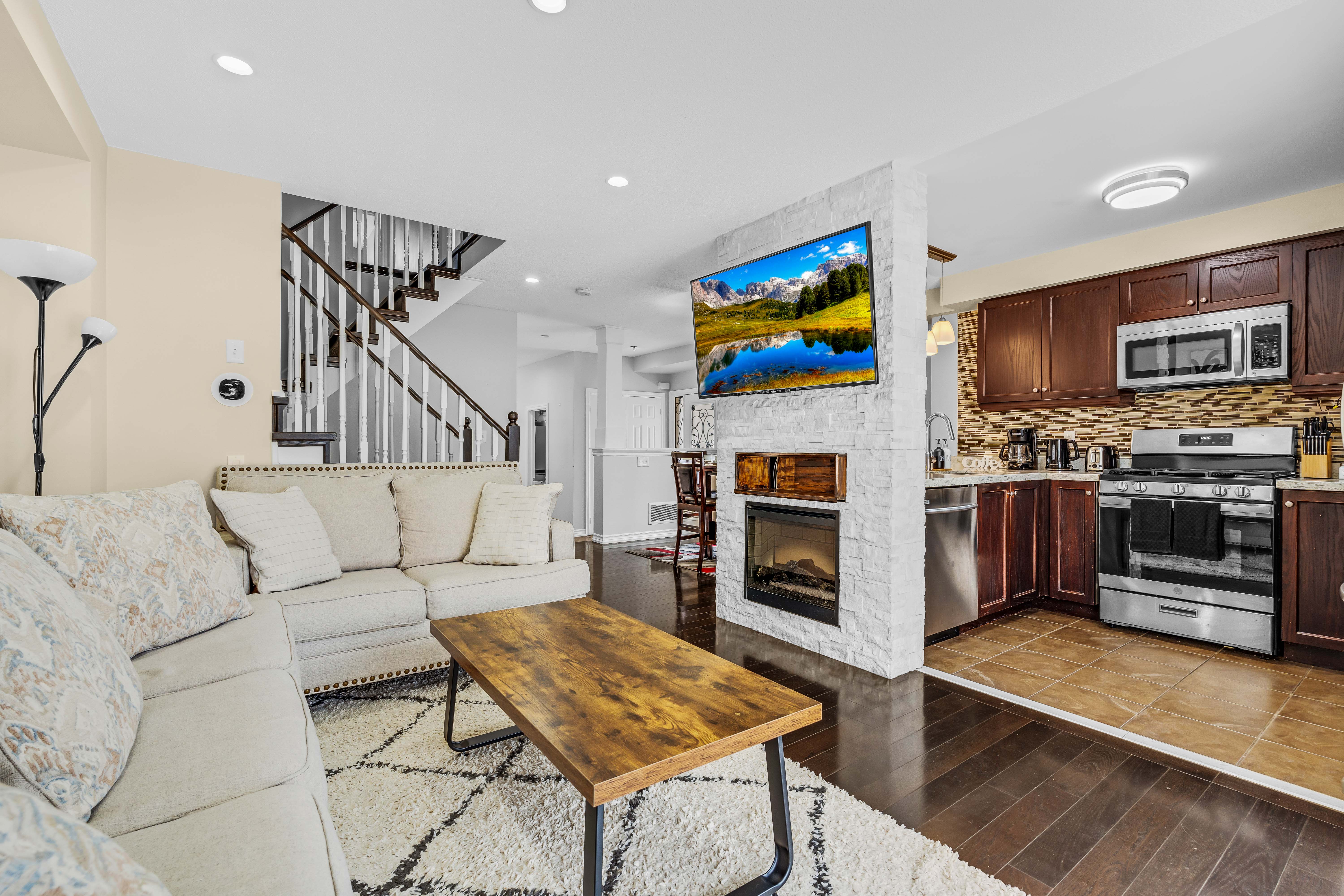 Open concept family room and kitchen with stone fireplace